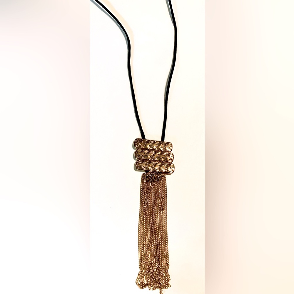 Golden colored necklace on black cord with matching earrings